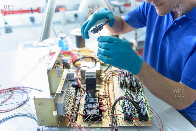 Worker fixing electronics in electronics factory