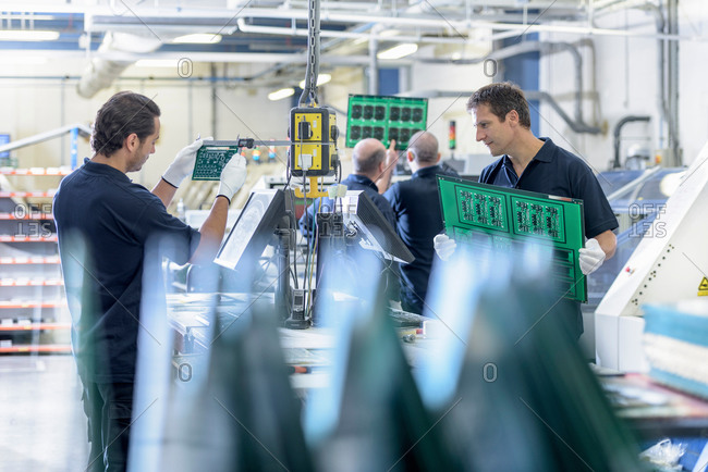 Workers inspecting circuit boards in circuit board factory