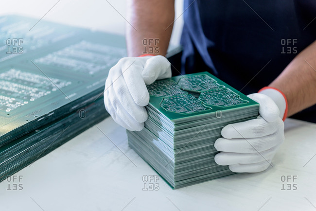 Worker arranging cut circuit boards in circuit board factory