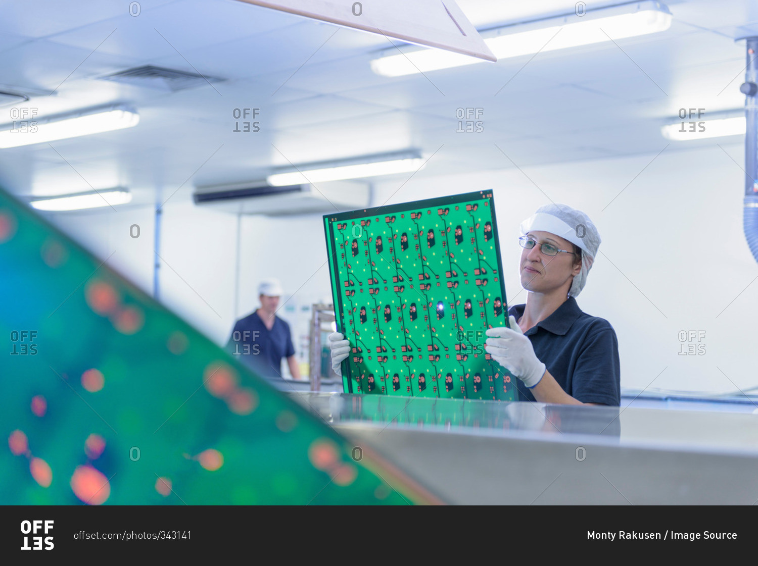 Female worker inspecting circuit boards