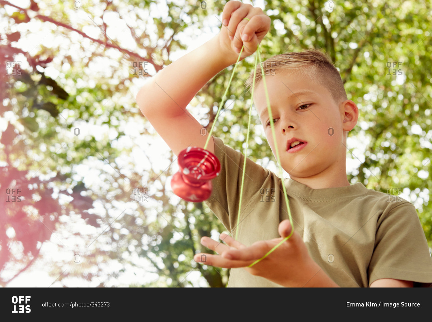 Low angle view of boy playing with yo-yo looking down
