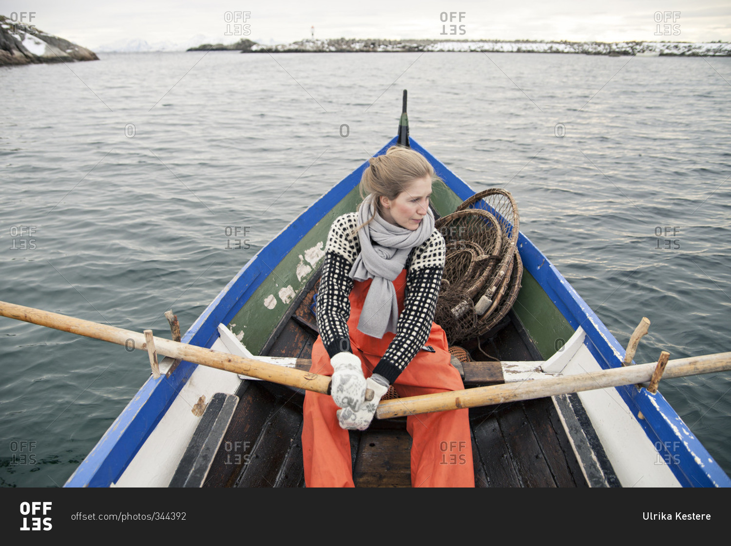 Norwegian fisherwoman rowing a boat in harbor