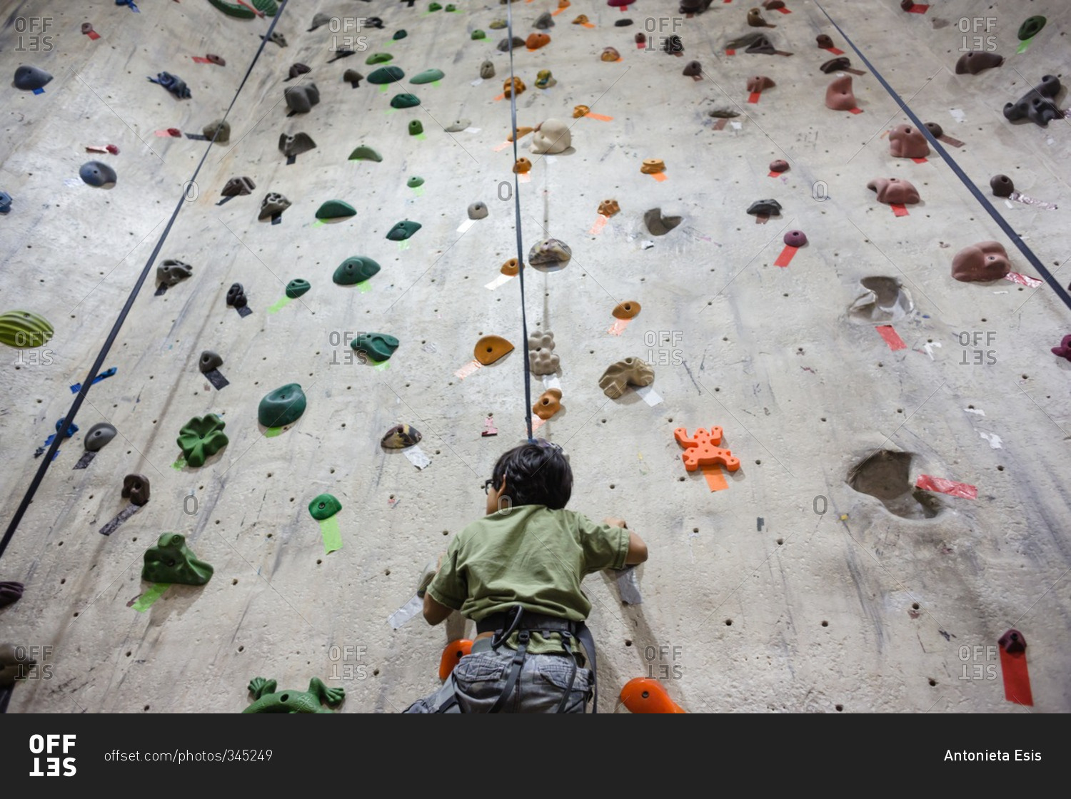 Boy scaling an indoor rock wall