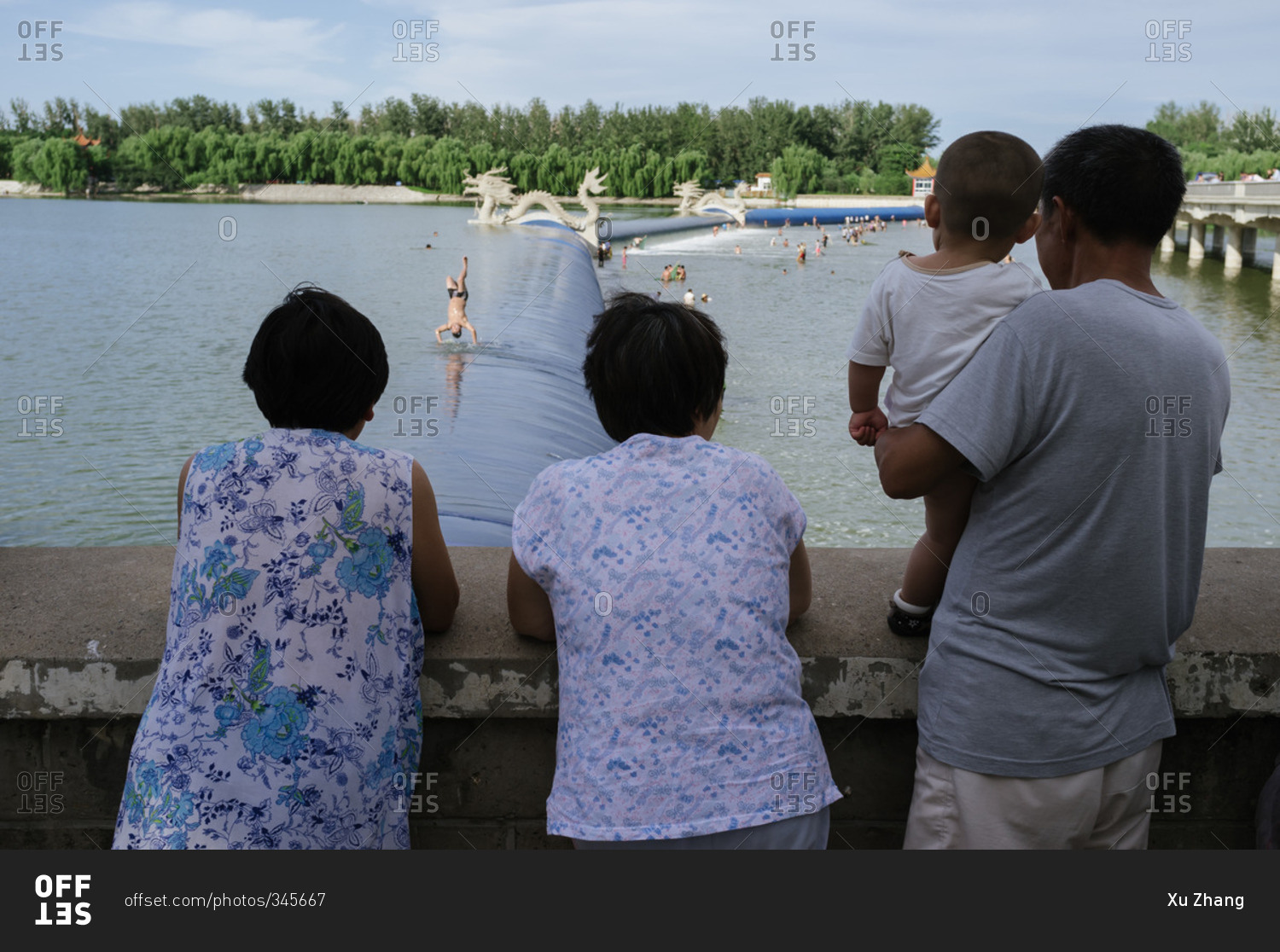 People looking at a river where people are swimming