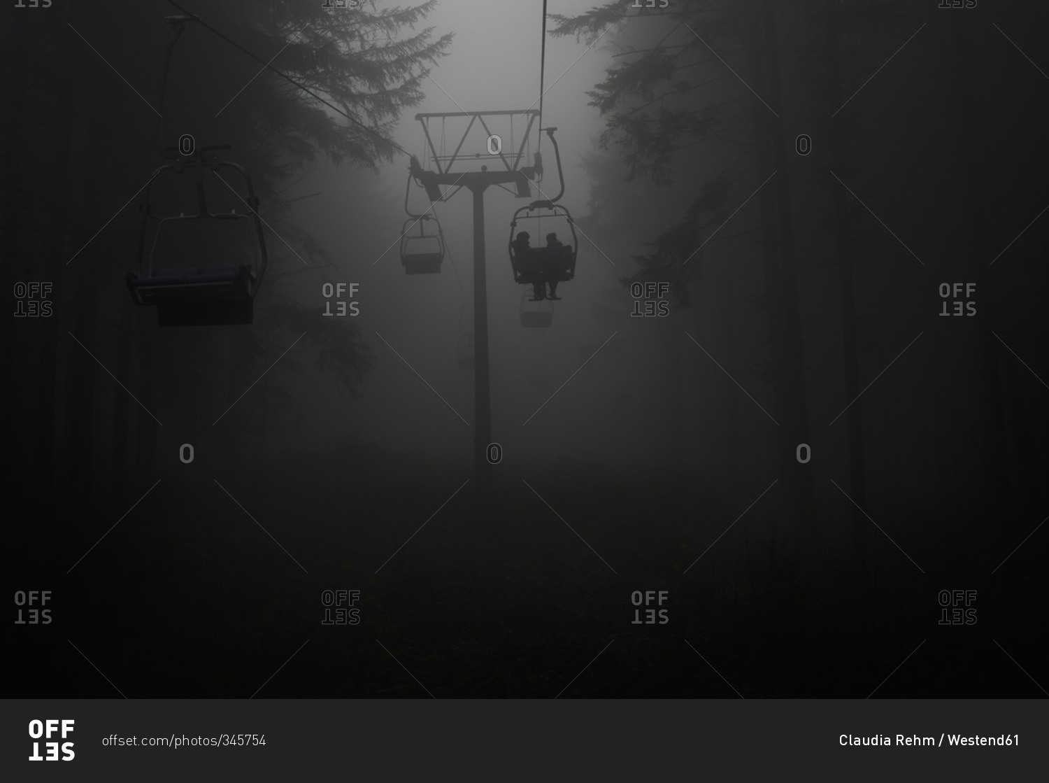 Germany, silhouettes of people using chairlift at haze