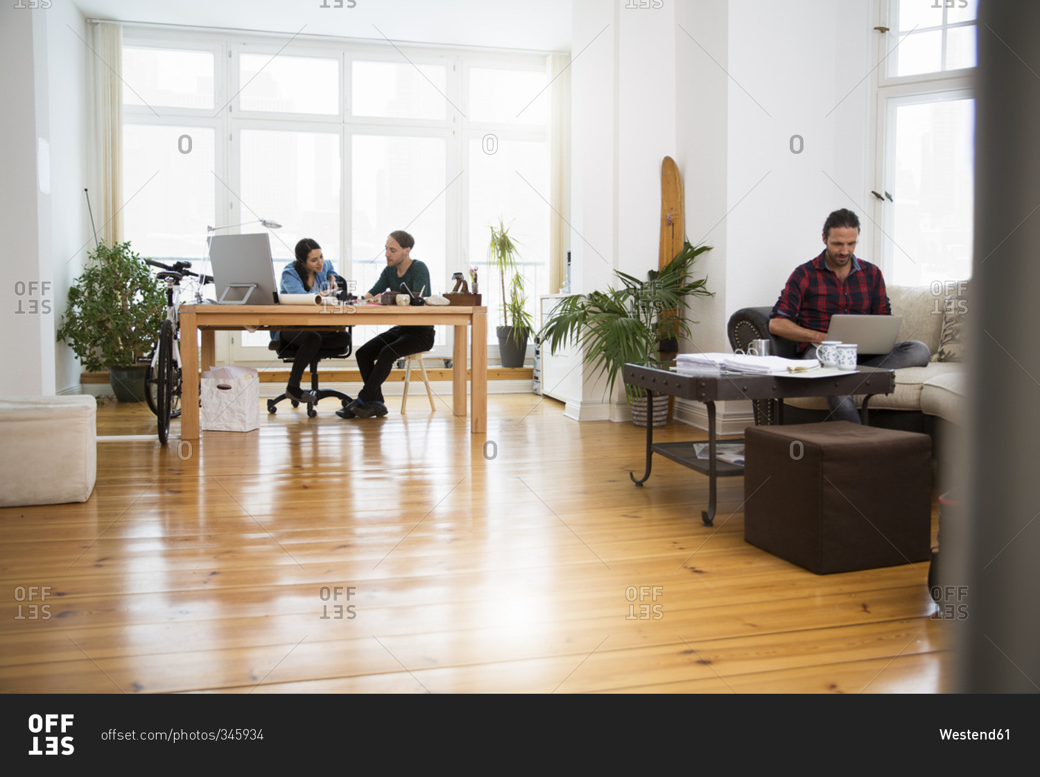 Three creative business people working in informal office