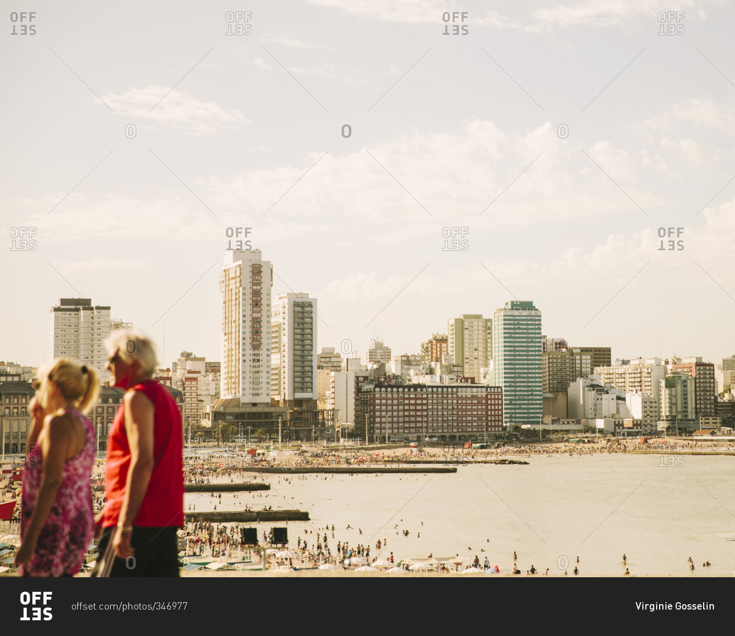 Crowded beach in front of a city skyline