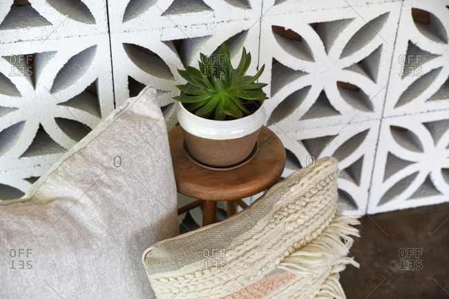 Throw pillows and a succulent against decorative cement blocks