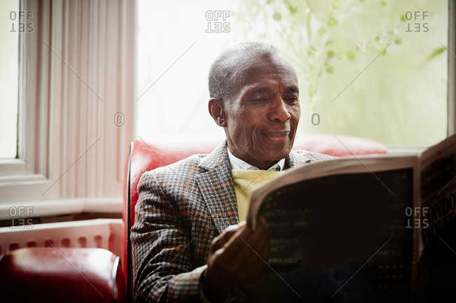 Elderly man reading newspaper