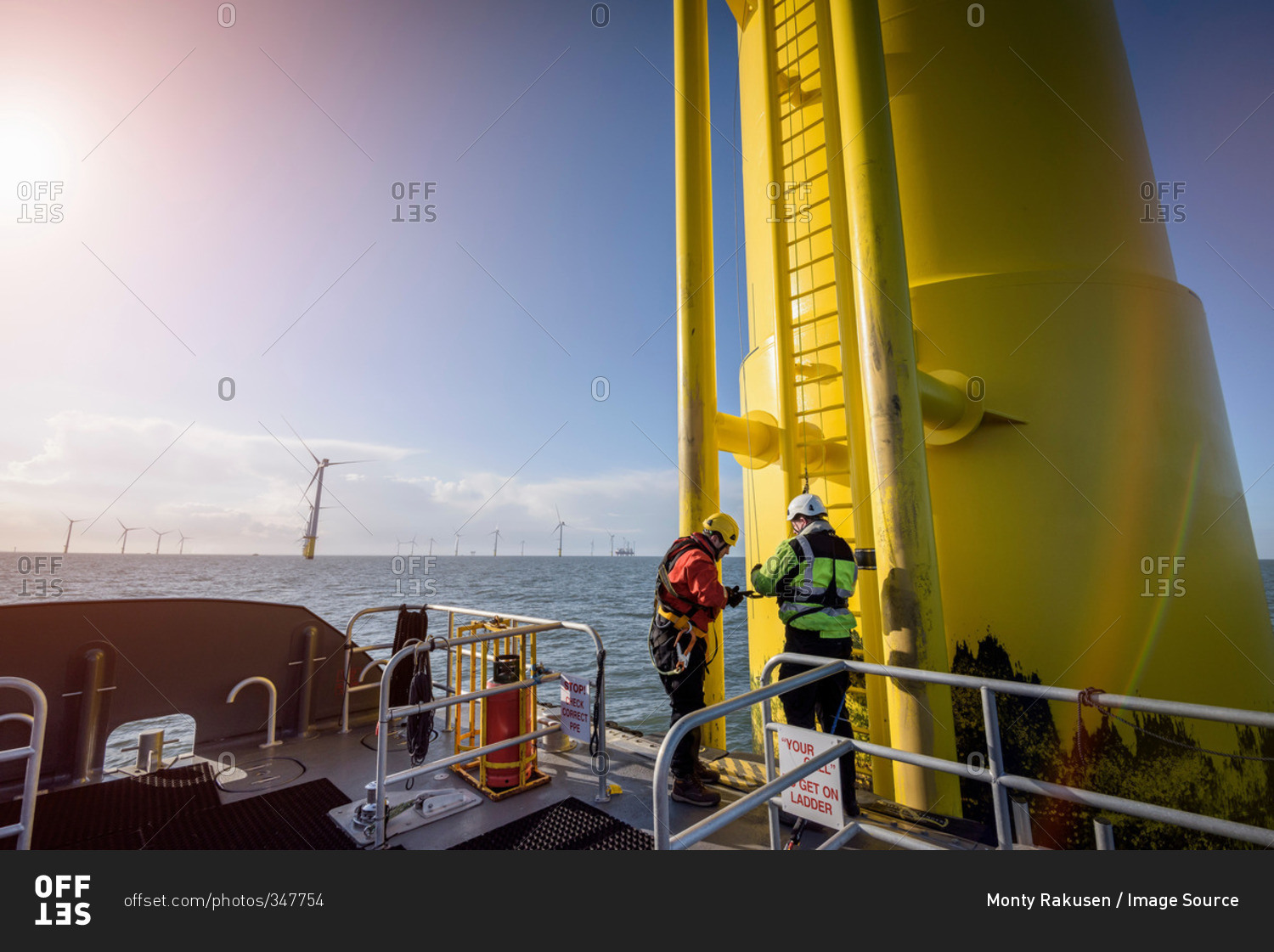 Engineers preparing to climb wind turbine at offshore wind farm