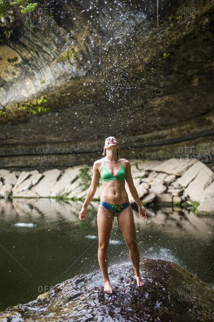A young woman enjoys the Hamilton Pool near Wimberley, Texas on a hot day.