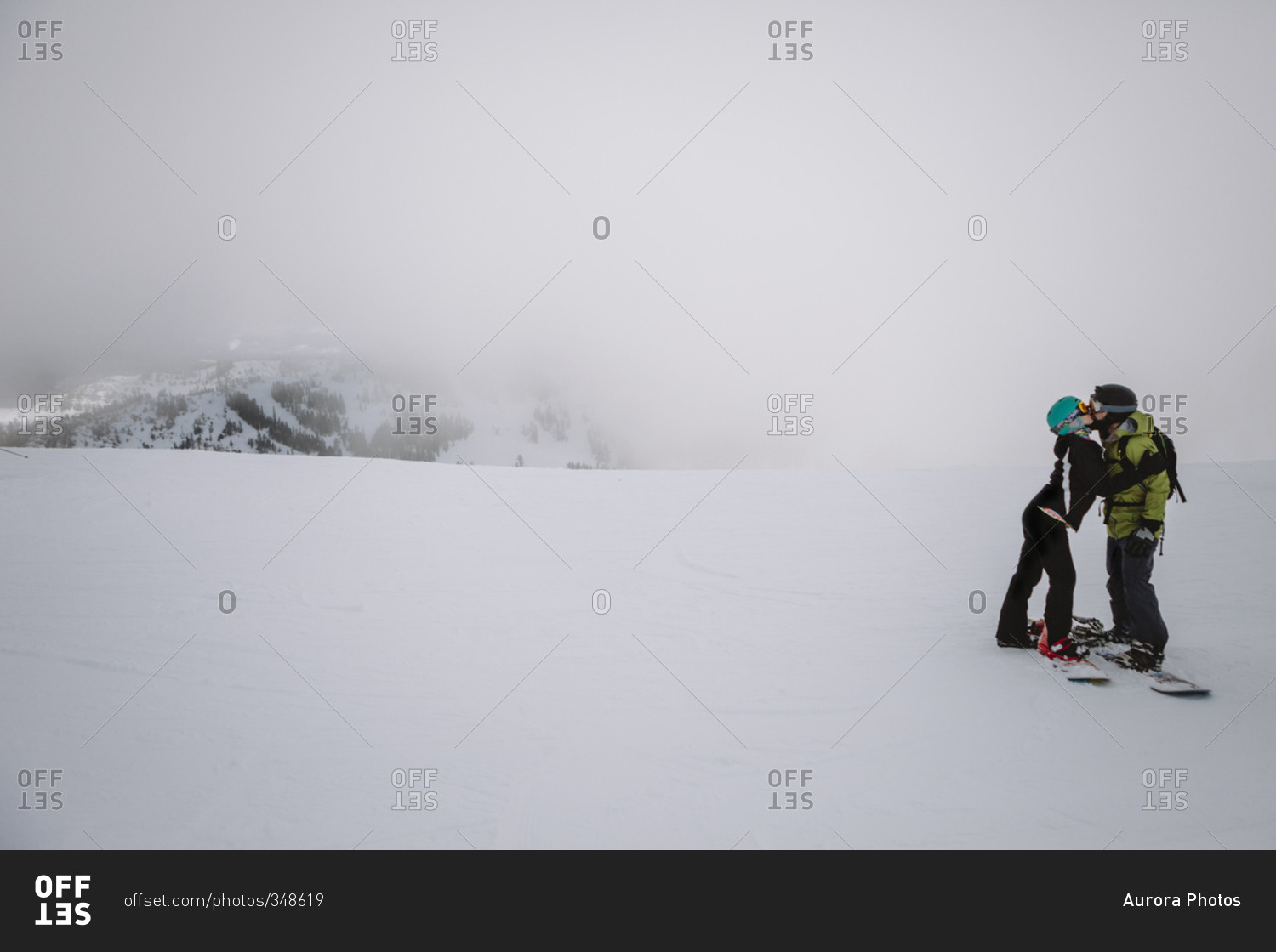 A couple kissing while snowboarding in Lake Tahoe