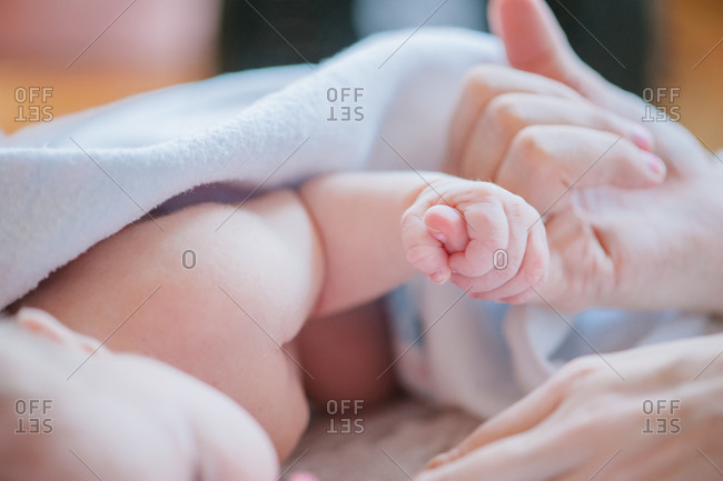 Close up of newborn gripping parent's finger
