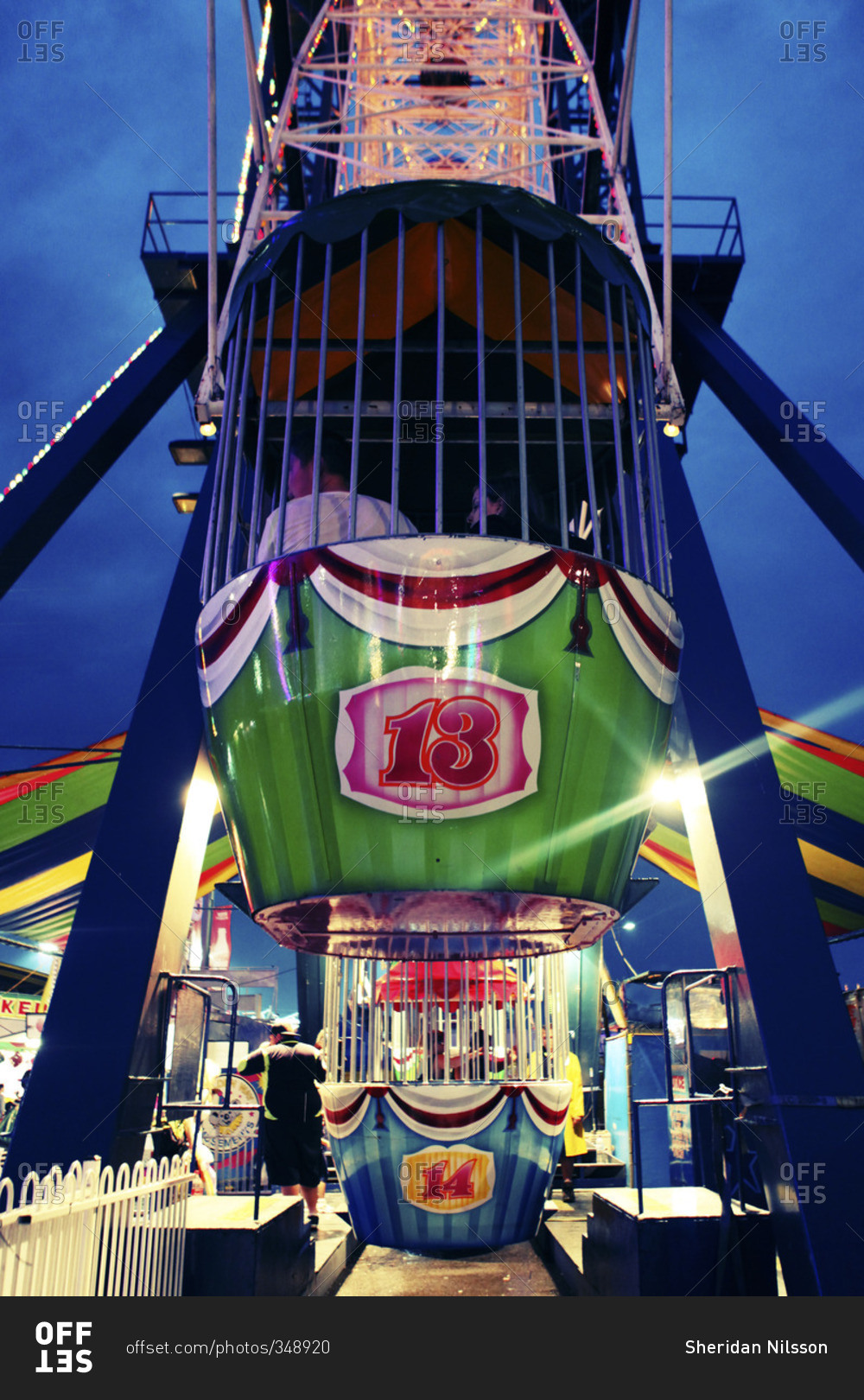 People riding in a carnival bucket ride at dusk