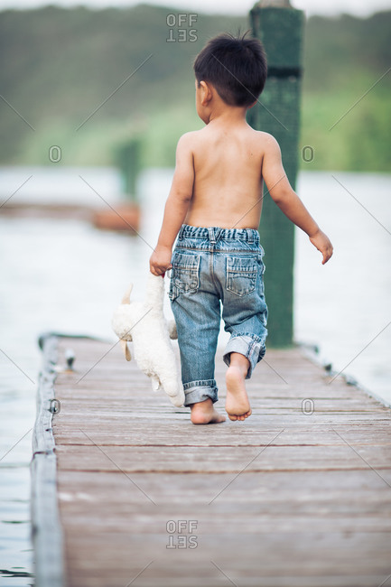 Little boy walking on a dock