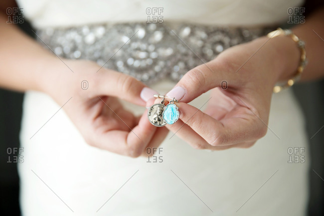 Bride holding two Catholic patron saint charms