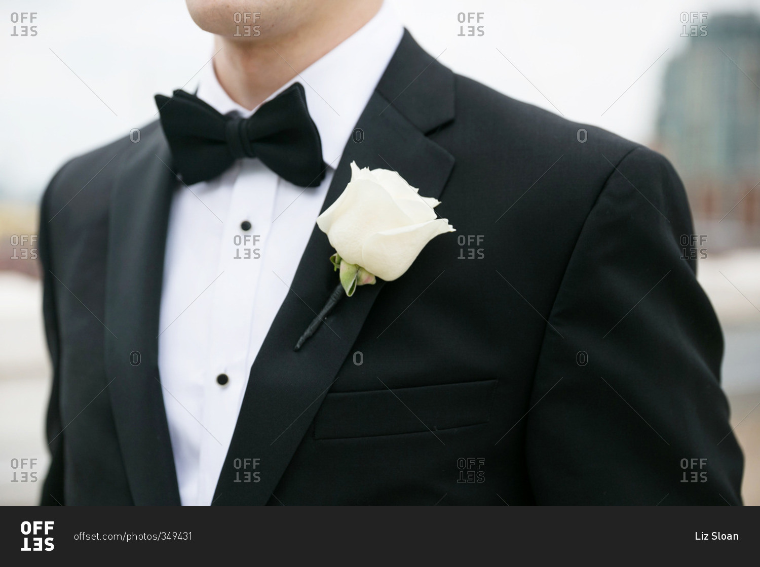 Groom wearing a tuxedo with a white rose on his lapel