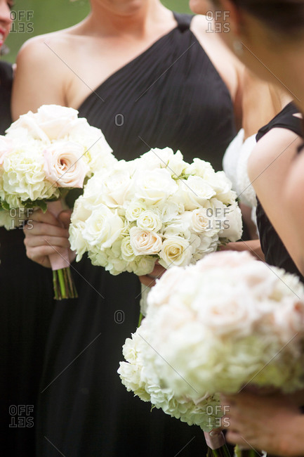 Bridesmaids in black dresses with white bouquets
