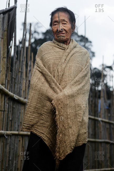 Arunachal pradesh, India - February 1, 2016: Portrait of an Apatani woman standing near a bamboo wall