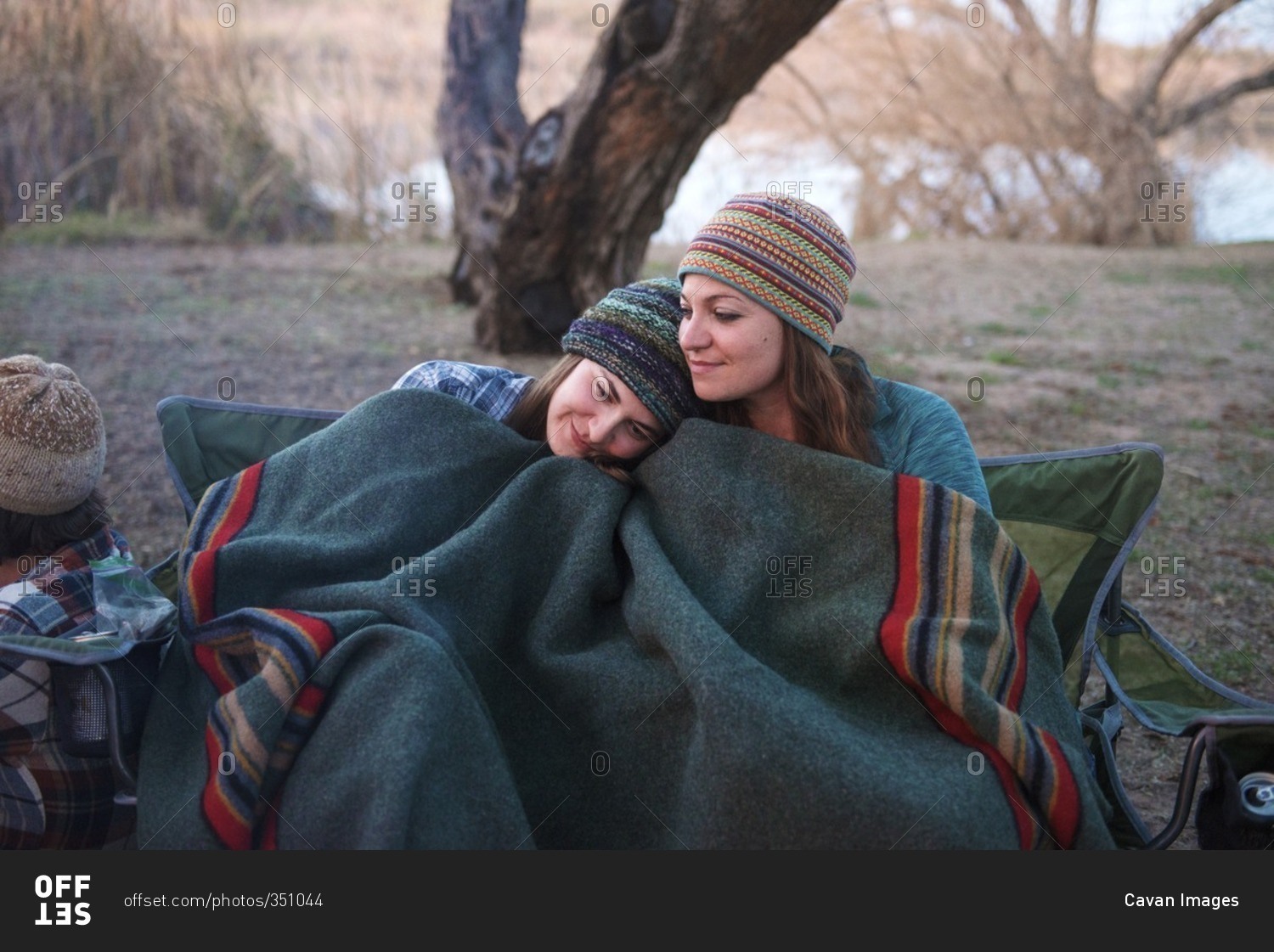 Two women cuddling on a camping trip