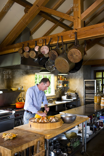 Seattle, Washington - November 14, 2013: A cook slicing the rind off a pumpkin in preparation for making homemade soup