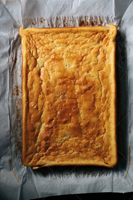 Golden sheet cake resting on parchment paper