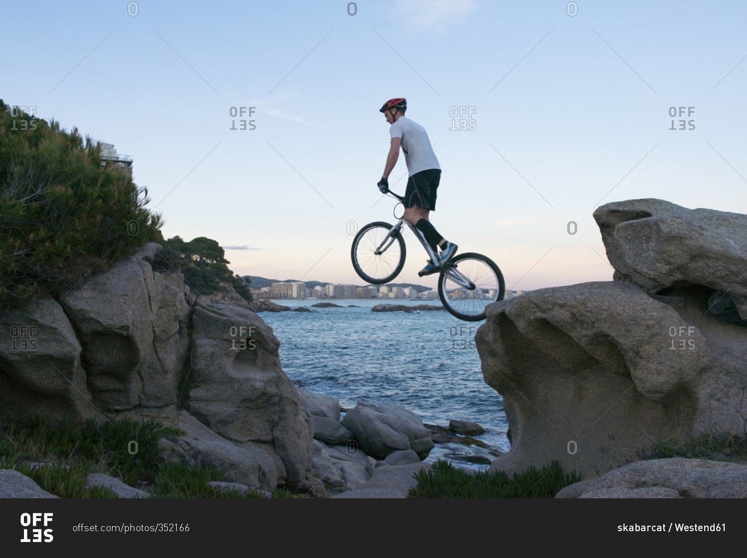 Bmx rider jumping from rock to  rock in the evening