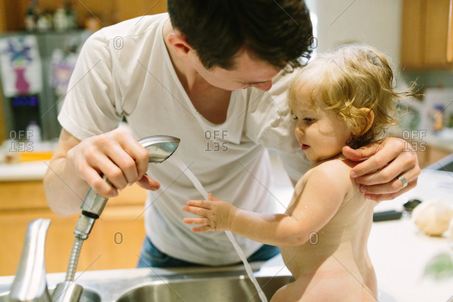 Toddler getting a bath in the kitchen sink stock photo ...