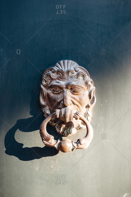 Ornate antique brass door knocker on a door in Aix-en-Provence, France