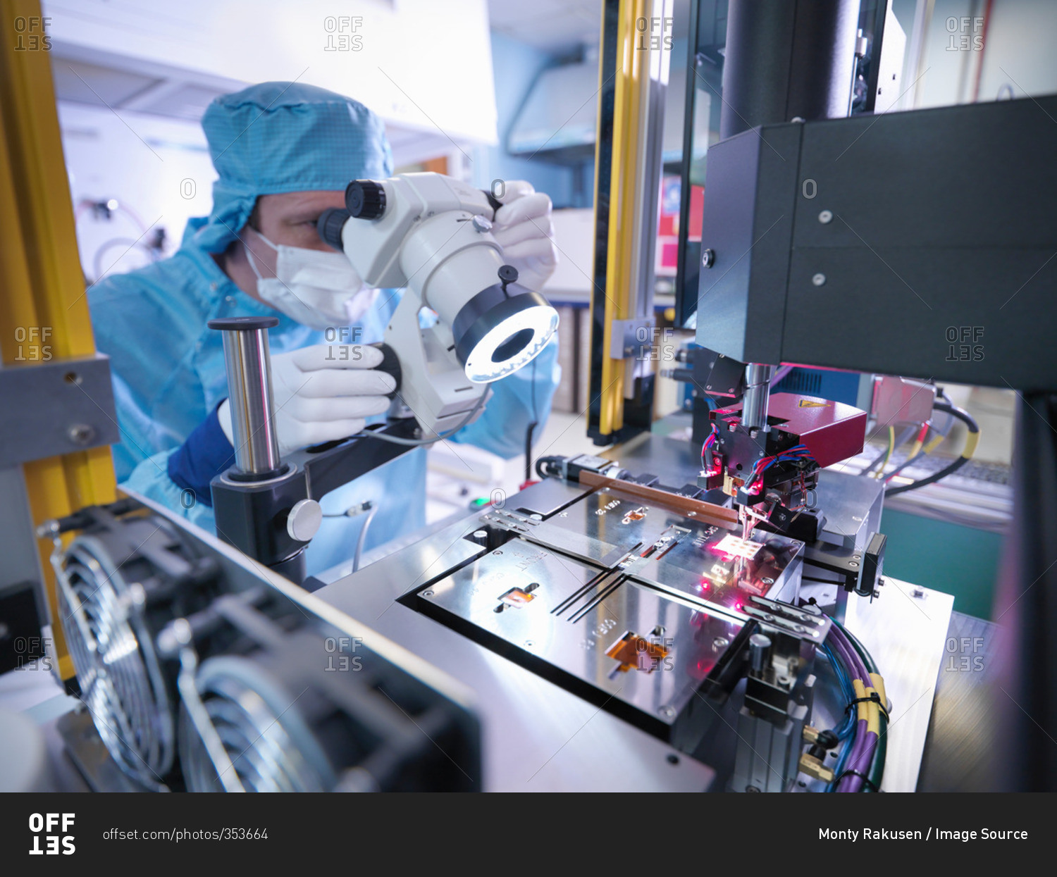 Electronics worker checking component in clean room