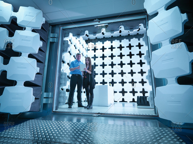 Engineers reviewing test results in laboratory in an anechoic chamber used for electromagnetic compatibility testing of electrical and electronic equipment