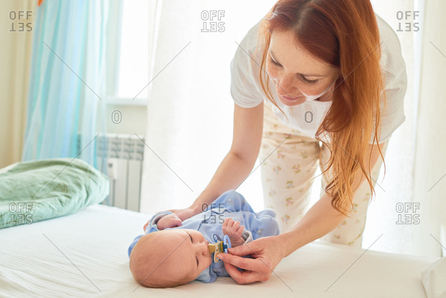 Mom giving baby pacifier