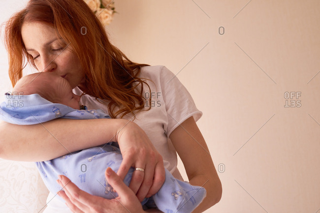 Mom giving newborn loving kiss