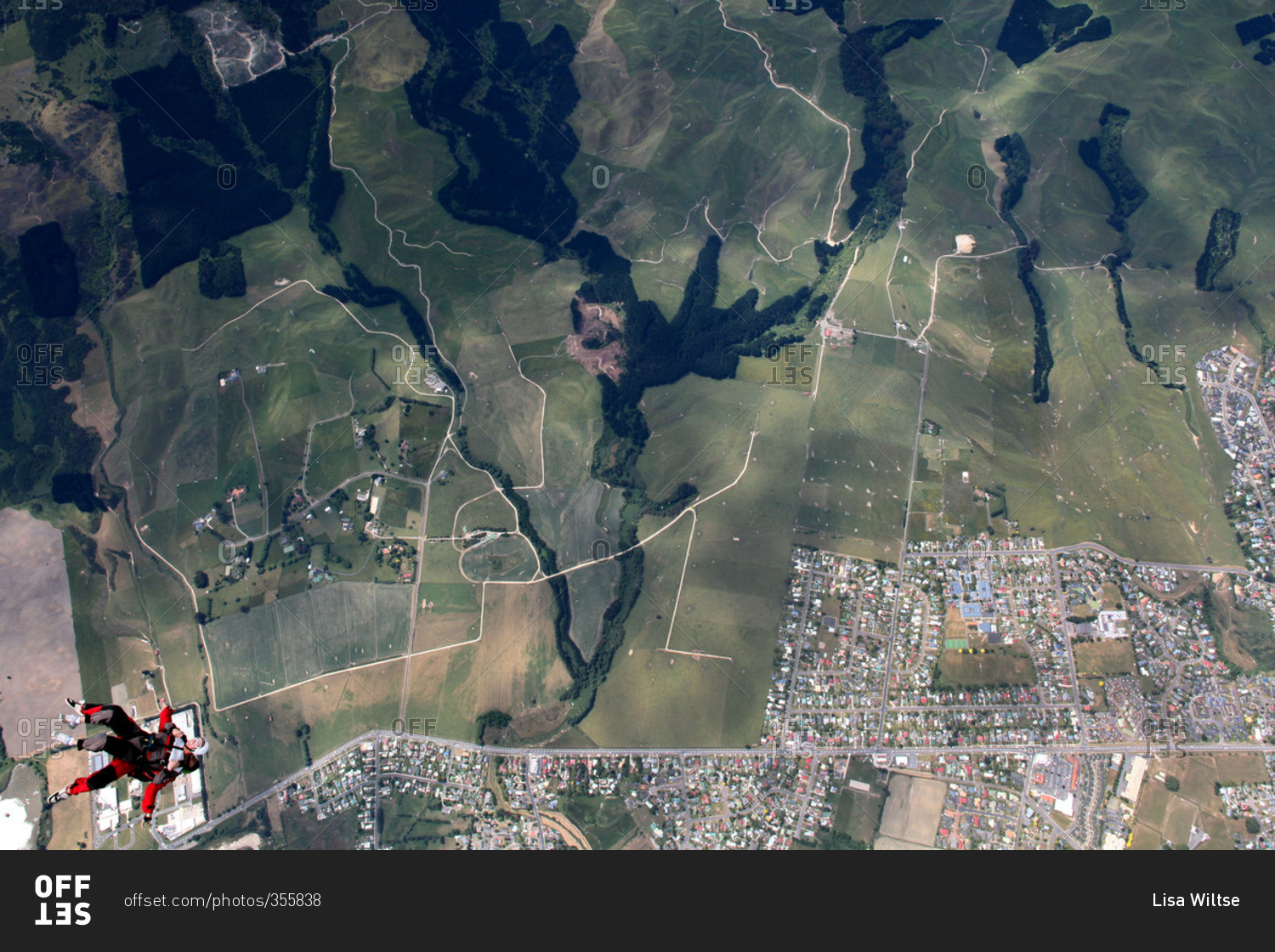 Skydivers over a patchwork of fields and neighborhoods near Rotorua, New Zealand