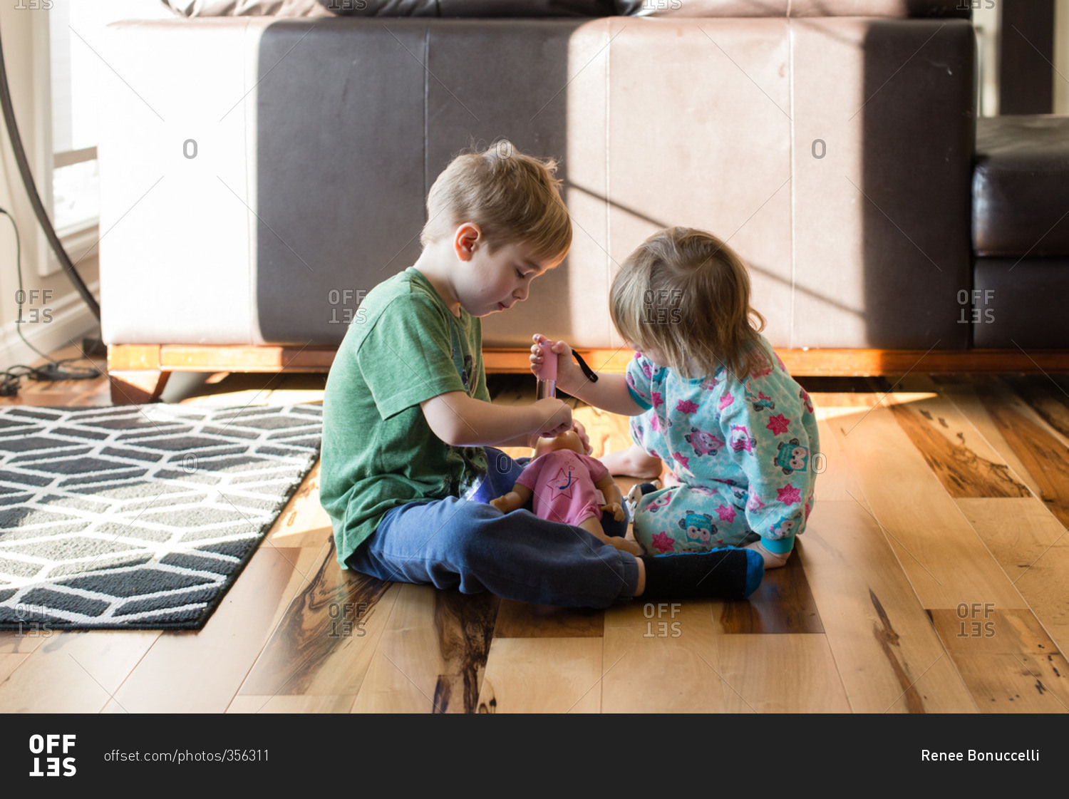 Boy and girl playing with doll