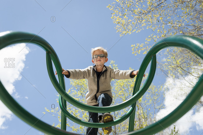 Boy on top of playground bars