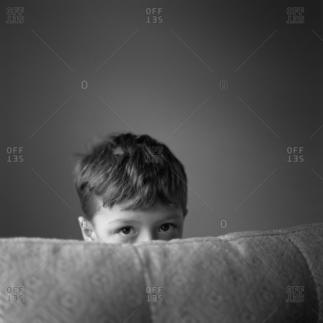 Boy peeking over sofa