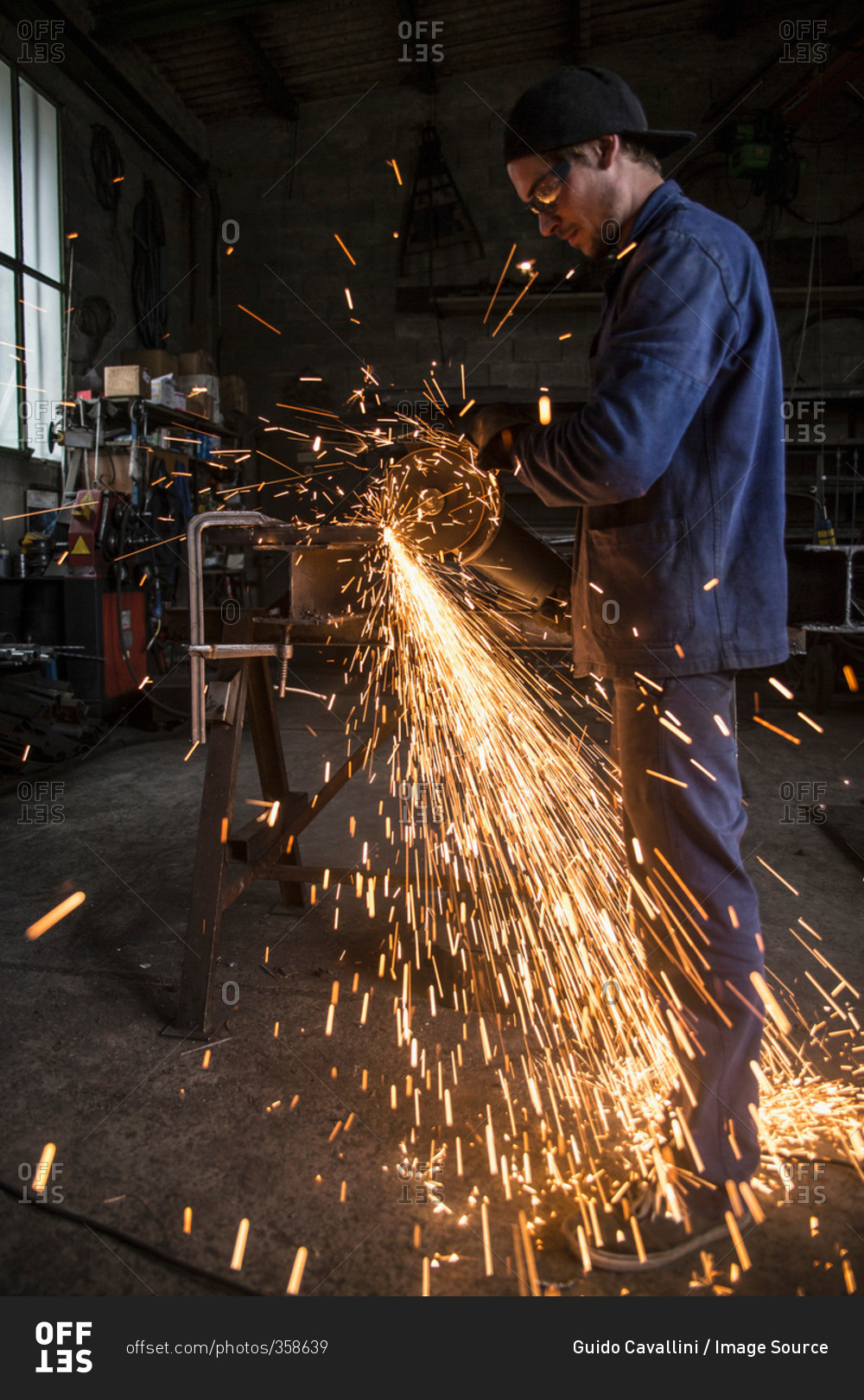 Welder cutting iron in workshop