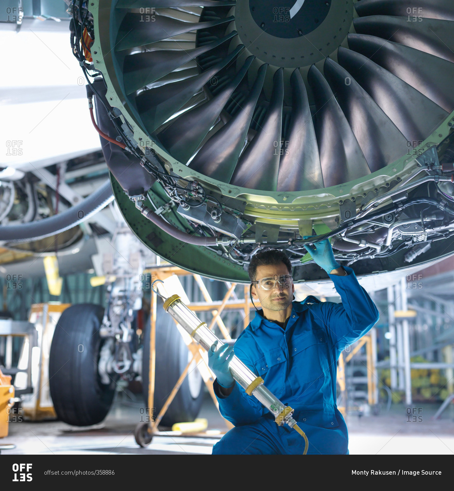 Portrait of engineer working on engine in aircraft maintenance factory