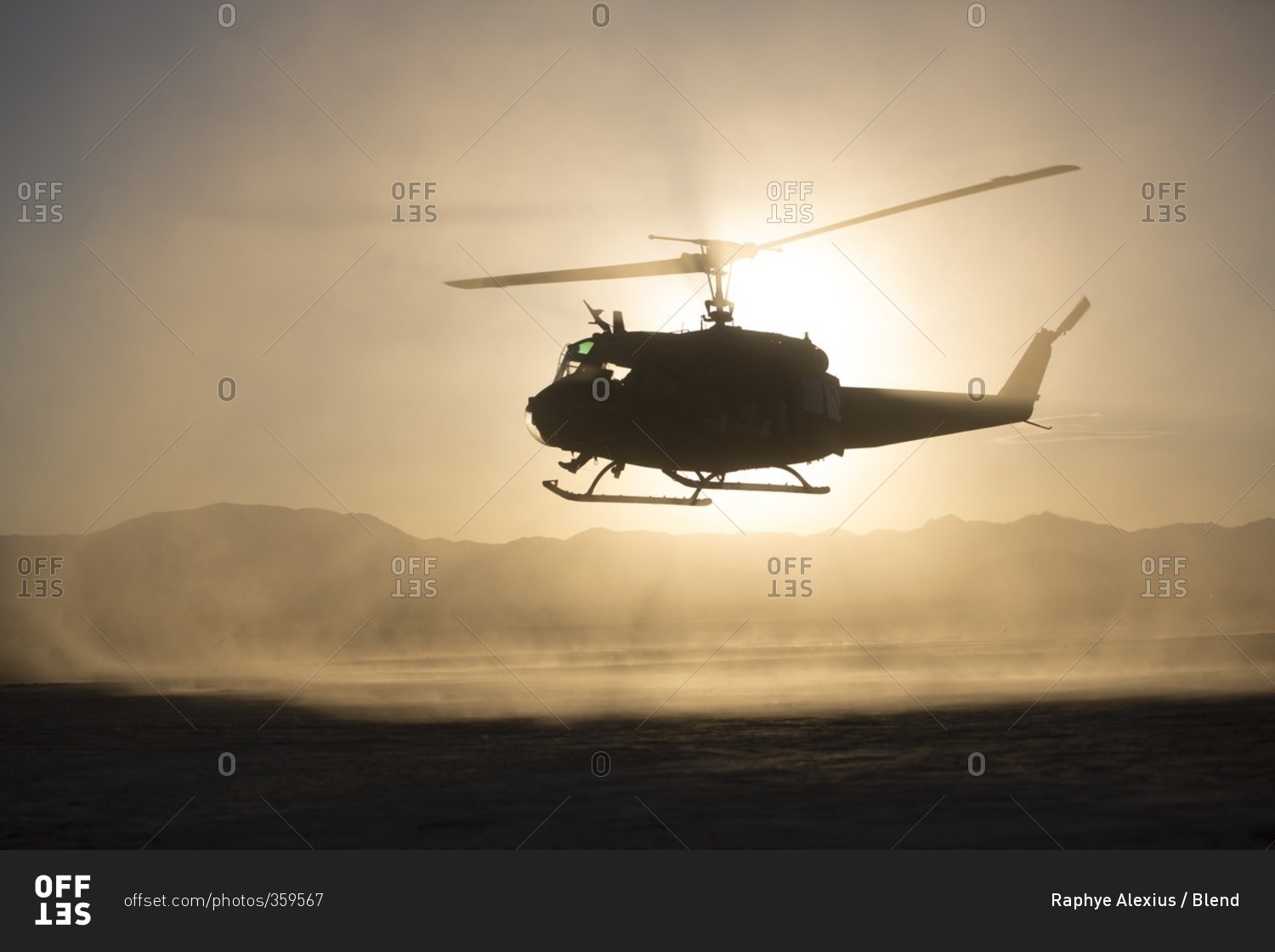 Silhouette of helicopter flying over remote landscape