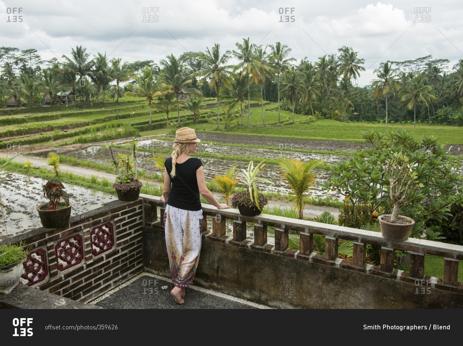 Caucasian woman admiring rural farm fields from rooftop