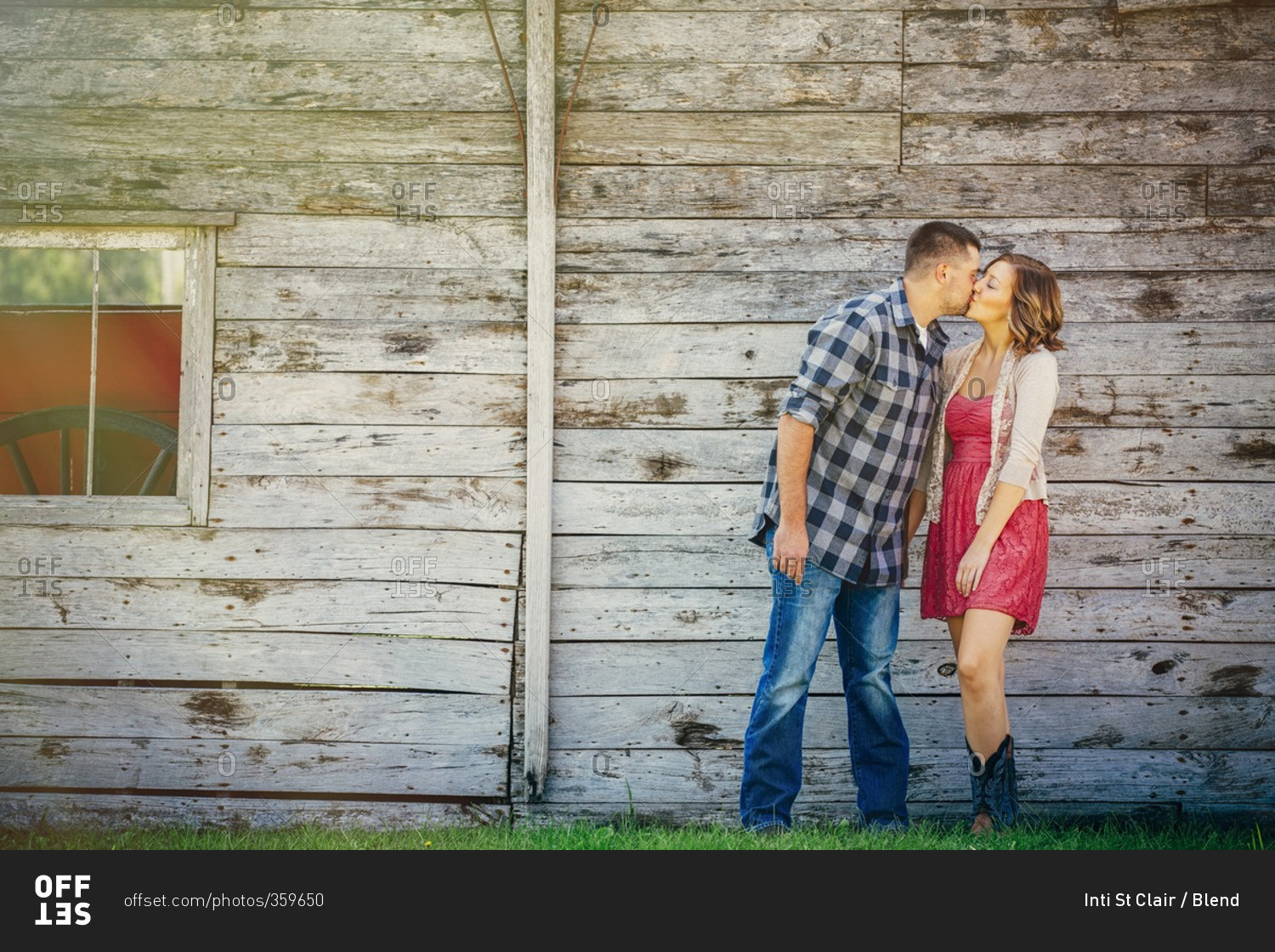 Caucasian couple kissing near wooden building