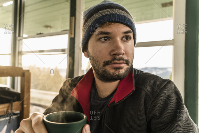 Man with steaming mug in cabin