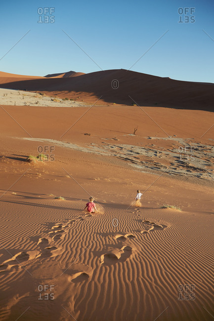 Two boys running down a sand dune, Dead Vlei, Sossusvlei, Namib National Naukluft Park