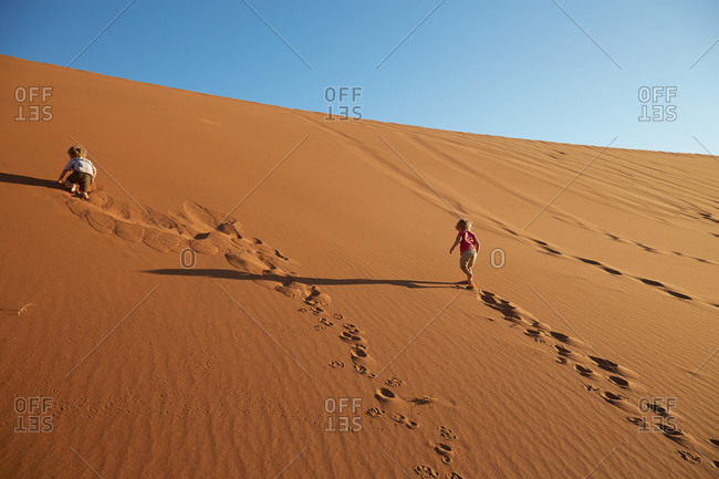 Two boys walking up a sand dune, Dead Vlei, Sossusvlei, Namib National Naukluft Park