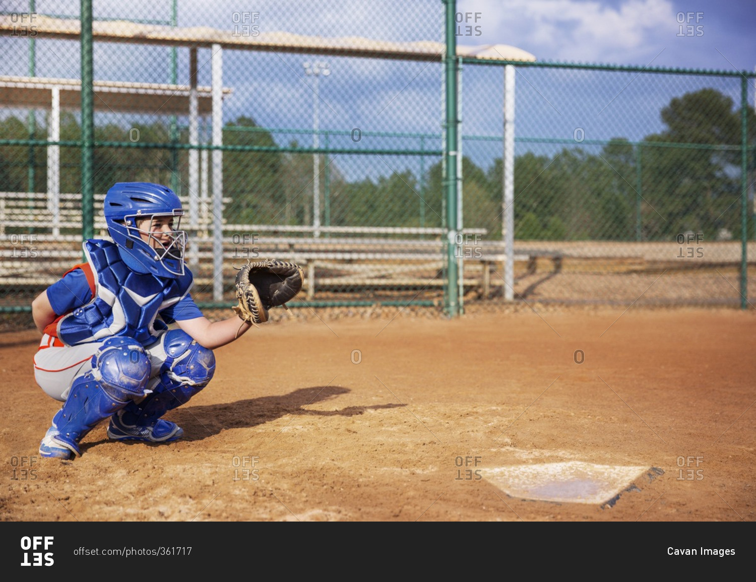 Baseball catcher crouching on field