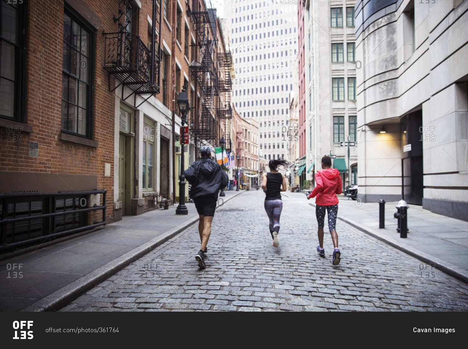 Rear view of multi-ethnic athletes running on city street