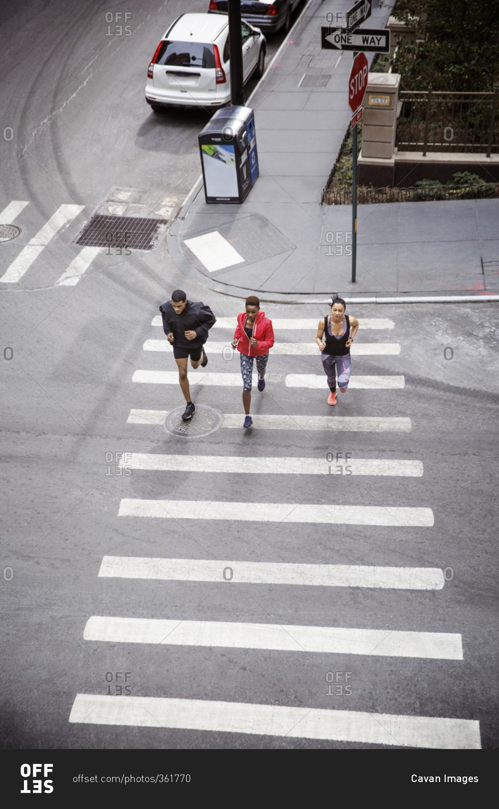 Overhead view of athletes running on zebra crossing on city street