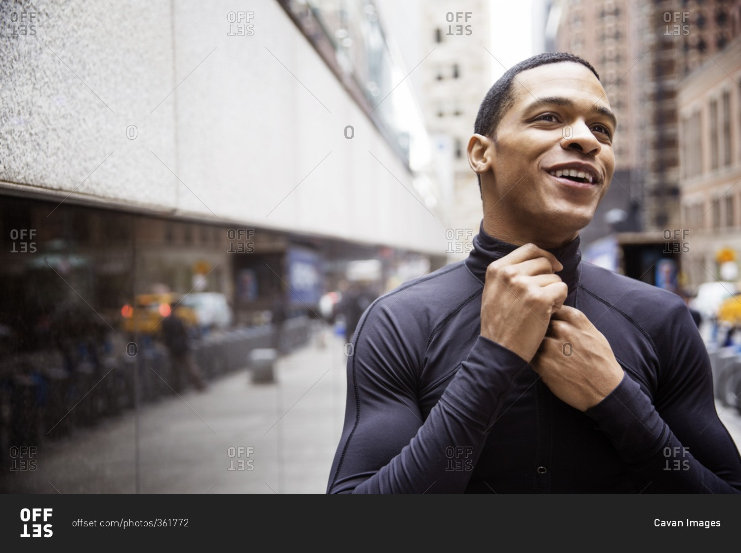 Happy male athlete wearing jacket on city street