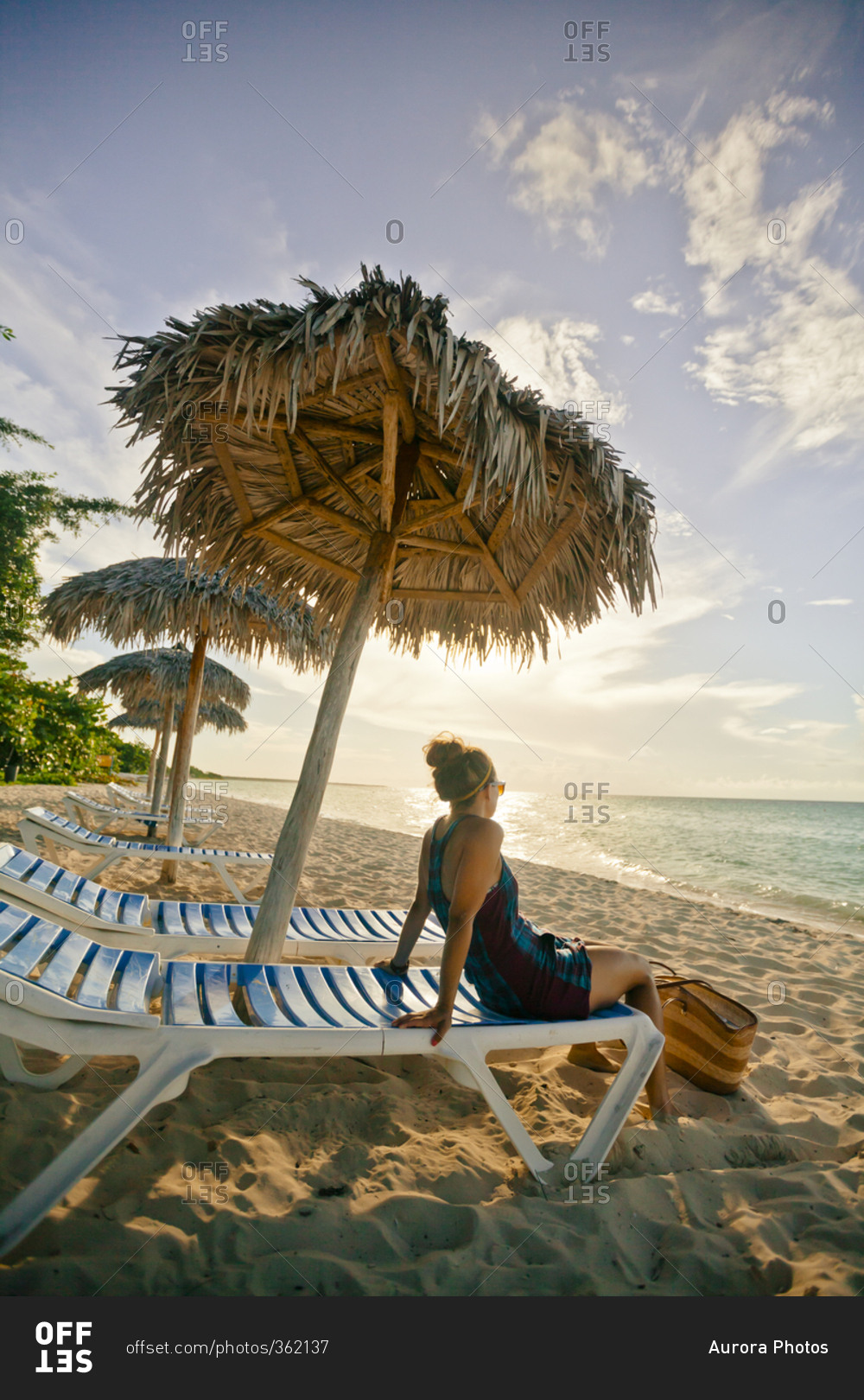 A young woman relaxing on the beach under a beach umbrella in Cayo Coco, Cuba